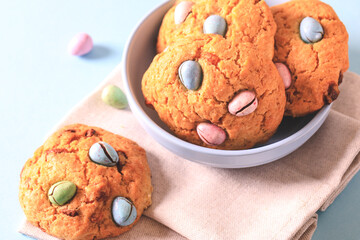 homemade cookies chocolate chips with colored candy eggs on a blue background