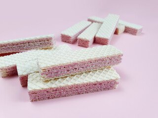 wafer sticks with pink strawberry filling on pale pink background. flatlay, top view. Sweet food.