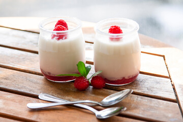 Greek yogurt with raspberries in glass jars