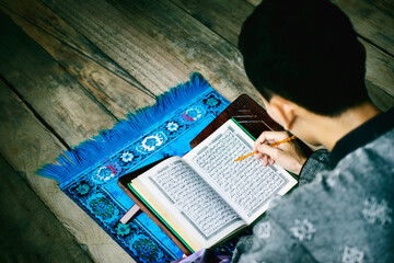 Top view of Muslim man reading Quran during ramadan