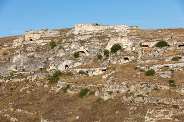 Fototapeta na wymiar View of Gravina river canyon and park of the Rupestrian Churches of Matera with houses in caves di Murgia Timone near ancient town Matera (Sassi), , Basilicata, Italy