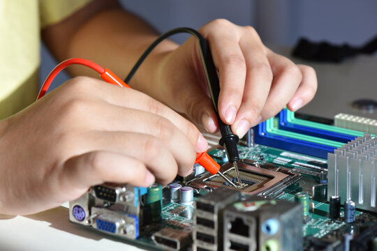Close up hands of a service worker repairing CPU board computer. Repairing and service concept