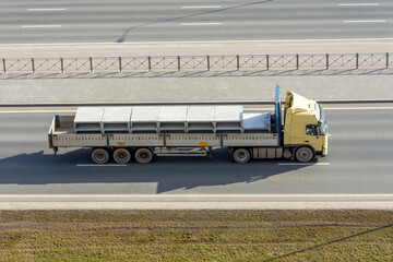 Truck with a fully loaded concrete block body with cement driving on the highway.