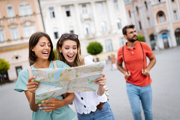 Happy traveling tourists sightseeing with map and having fun