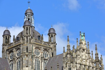 Fototapeta na wymiar The external facade of the Gothic church St Janskathedraal (St John's Cathedral) in Hertogenbosch, Netherlands , with statues and ornaments