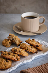 Fragrant oatmeal biscuits on a plate with openwork edges on a gray table