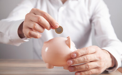 Man putting coin to piggy bank. Saving