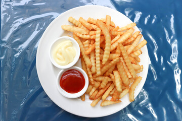 French fries or fried potato with tomato sauce and mayonnaise