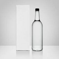 Glass bottle and box with copy space on white backdrop