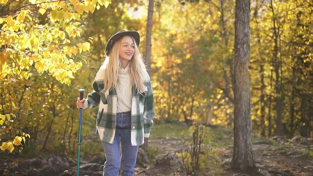 Happy caucasian blonde woman is enjoying time in the forest, attractive female in casual wear, outdoor recreation. Slow motion