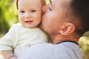 Happy young father spending time together with little daughter outdoors