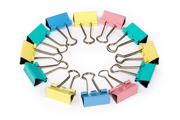 Multi colored binder clips laid out circle on white background
