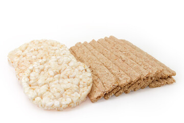 Flat rye-wheat and puffed rice crispbreads on white background