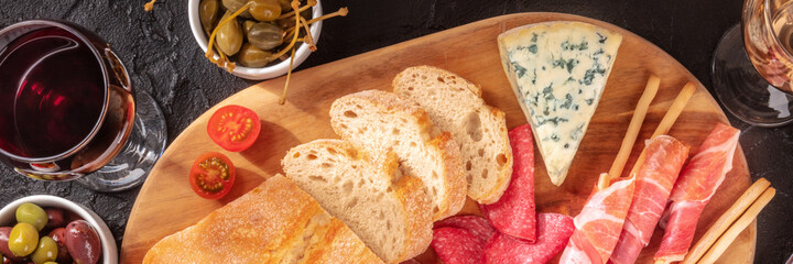 Italian antipasti panorama with wine, bread, cheese, and ham