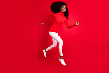 Fototapeta na wymiar Full body profile side photo of young afro woman happy positive smile jump up go walk run hurry sale isolated over red color background