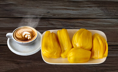 a cup of  coffee with jackfruit in white dish on wooden table,