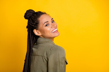 Photo portrait of cute charming girl smiling laughing looking behind back isolated on vivid yellow...