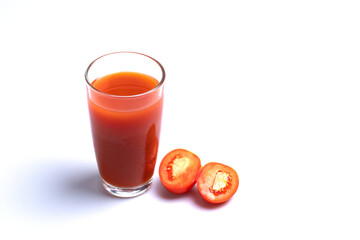 Tomato juice in a transparent glass on a white background