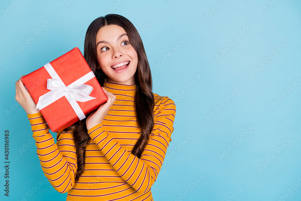 Sticker Photo of little astonished lady hands hold giftbox open mouth look empty space isolated on blue color background