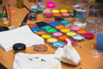 Obraz na płótnie Canvas Everything you need to create aqua makeup (paints, napkins, cups of water) is on the table. 