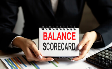 business woman holding a notebook with the text Balance Scorecard