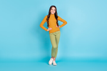 Fototapeta premium Full size photo of adorable satisfied school person standing put hands on waist isolated on blue color background