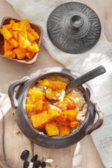 Delicious porridge with baked pumpkin seeds and spices in a ceramic bowl on a wooden table. healthy homemade breakfast. selective focus. Millet, wheat and rice porridge with pumpkin 