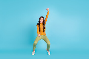 Full size photo of cheerful carefree pupil standing on tiptoe raise hand open mouth isolated on blue color background