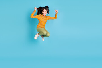 Fototapeta premium Full length portrait of astonished energetic pupil fists up toothy smile success isolated on blue color background