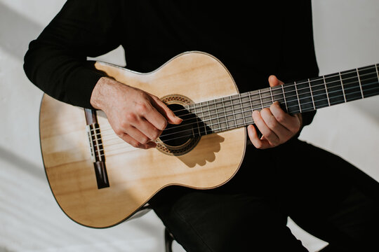 photo of man playing classical guitar