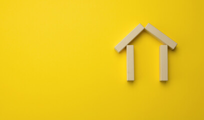 Fototapeta na wymiar wooden miniature house on a yellow background. The concept of buying and selling a house, renting and leasing real estate