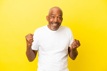 Cuban Senior isolated on yellow background celebrating a victory in winner position