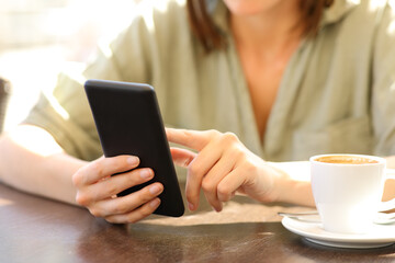 Woman hands using a smart phone in a coffee shop