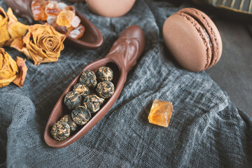 Fermented Chinese tea in a ceramic scoop with almond cookies on a wooden table background, selective focus. Top view