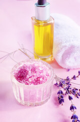 Obraz na płótnie Canvas Lavender salt with natural spa products and bath decor on a pink background