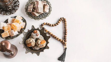 bowl with various pieces of Turkish delight locum and black tea with mint on a light background. Oriental sweets. copy space. Top view