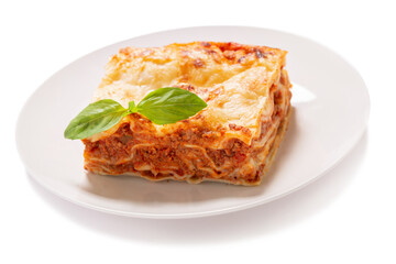 plate of lasagna with green basil on white background