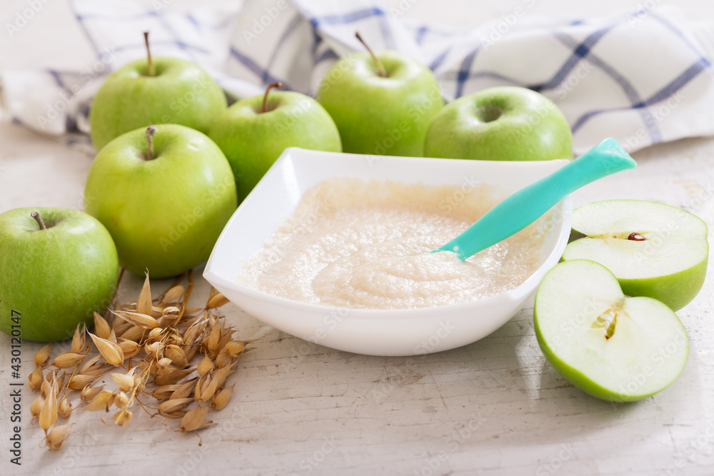 Wall mural baby food. bowl of oatmeal porridge with fresh apples