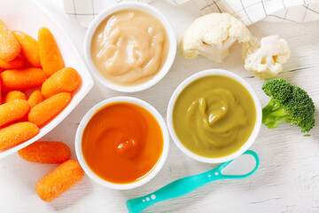 Baby food. Various kinds of bowls of fruit and vegetable puree with fresh vegetables