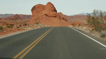 Road trip, driving auto in Valley of Fire, Las Vegas, Nevada, USA. Hitchhiking traveling in America, highway journey. Red alien rock formation, Mojave desert wilderness looks like Mars. View from car.