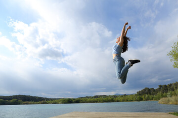 Happy woman jumping in a lake © PheelingsMedia