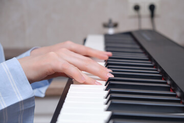 Obraz premium Woman musician playing piano at home kitchen, hands close up