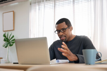 African American man having video conference with colleague at home. Black African Male freelancer using laptop in online meeting