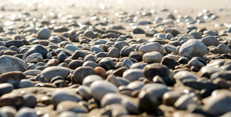 A close up view of smooth polished multicolored stones washed ashore on the beach. High quality photo