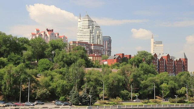 ars go along the street against the background of buildings, towers, skyscrapers, park in the city  Dnepropetrovsk, Dnipro, Ukraine. Beautiful view from Monastyrsky Island in spring and summer