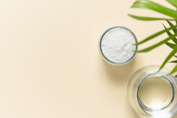 Collagen powder and a glass of water on a beige background with a copy space. Extra protein intake