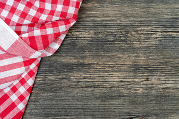 Red checkered towel on the kitchen table. Wooden table background.