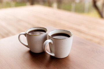 Two cups of coffee on the table on the wooden brown terrace