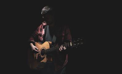 Male guitarist playing acoustic guitar copy space.