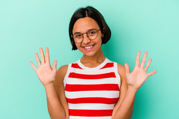 Young mixed race woman isolated on blue background showing number ten with hands.